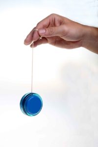 Close-up of a hand holding a blue yo-yo by its string.