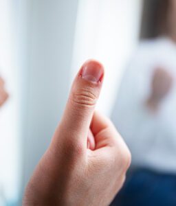 Close-up of a hand giving a thumbs-up with a blurred background.