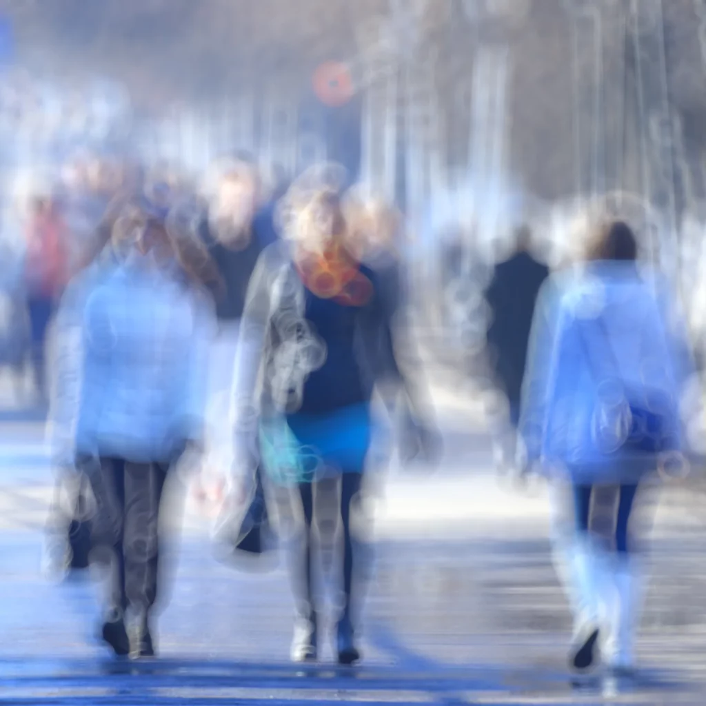 Abstract image of people walking down a street, appearing blurred, illustrating vision issues such as convergence insufficiency.