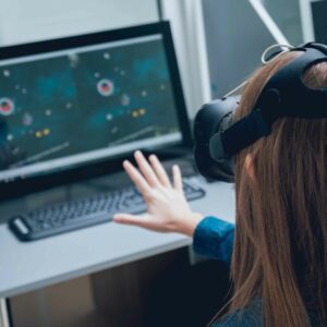 Person using a virtual reality headset, reaching out toward a screen, illustrating VR therapy for vision-related ADHD.