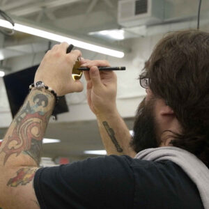 Chadwick Optical employee inspects a lens closely, using a marker to mark specific points on the lens.