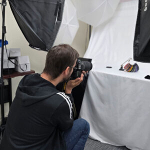 Andrew, Marketing Associate, photographing product samples in a studio setup.