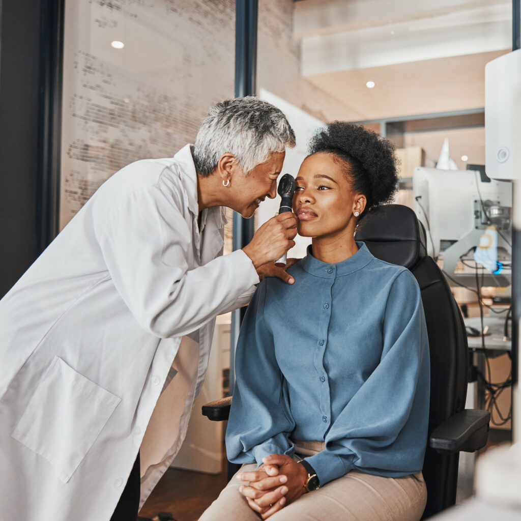 Doctor, vision or black woman in eye exam consultation or assessment for eyesight at optometrist office. Mature or senior optician helping a customer testing or checking iris or retina visual health