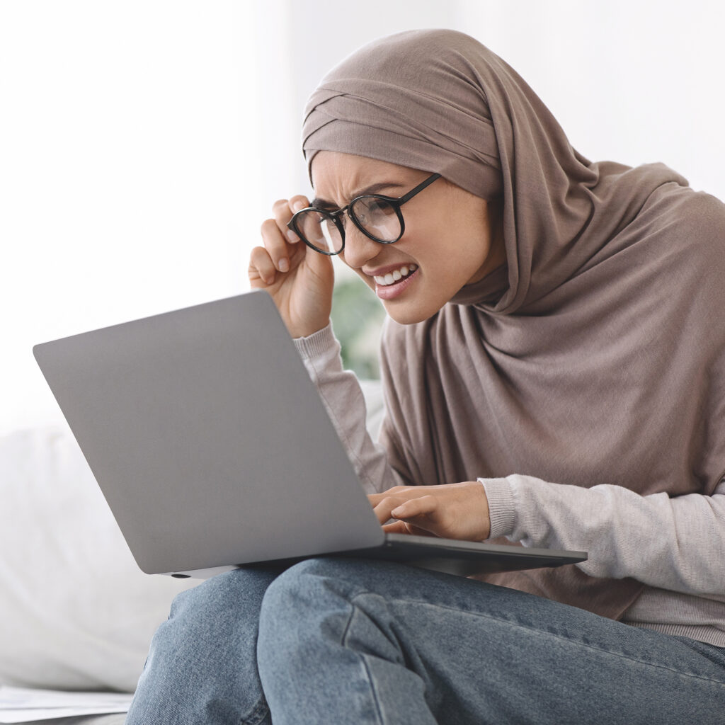 Eyesight,Problems.,Muslim,Woman,In,Hijab,Squinting,Eyes,While,Looking Eyesight problems. Muslim Woman In Hijab Squinting Eyes While Looking At Laptop Screen, Having Vision Problem, Copy Space