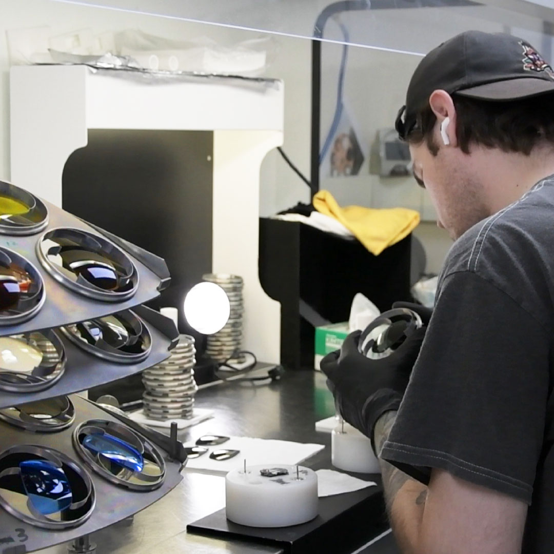 Technician preparing lenses for anti-reflective coating