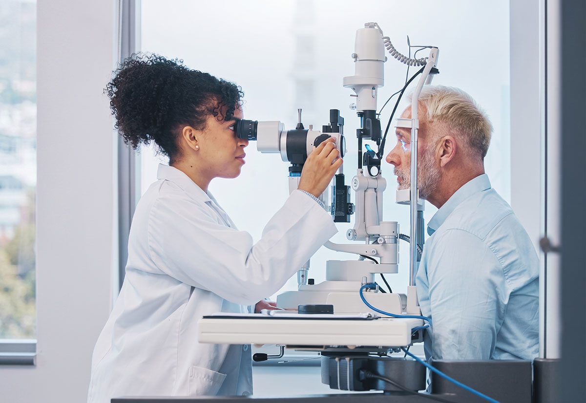 Optometrist examining a patient's eyes with a slit lamp
