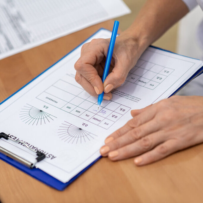Doctor,Making,Notes.,Close,Up,Of,Eye,Doctor,Making,Notes optometrist writing prescription